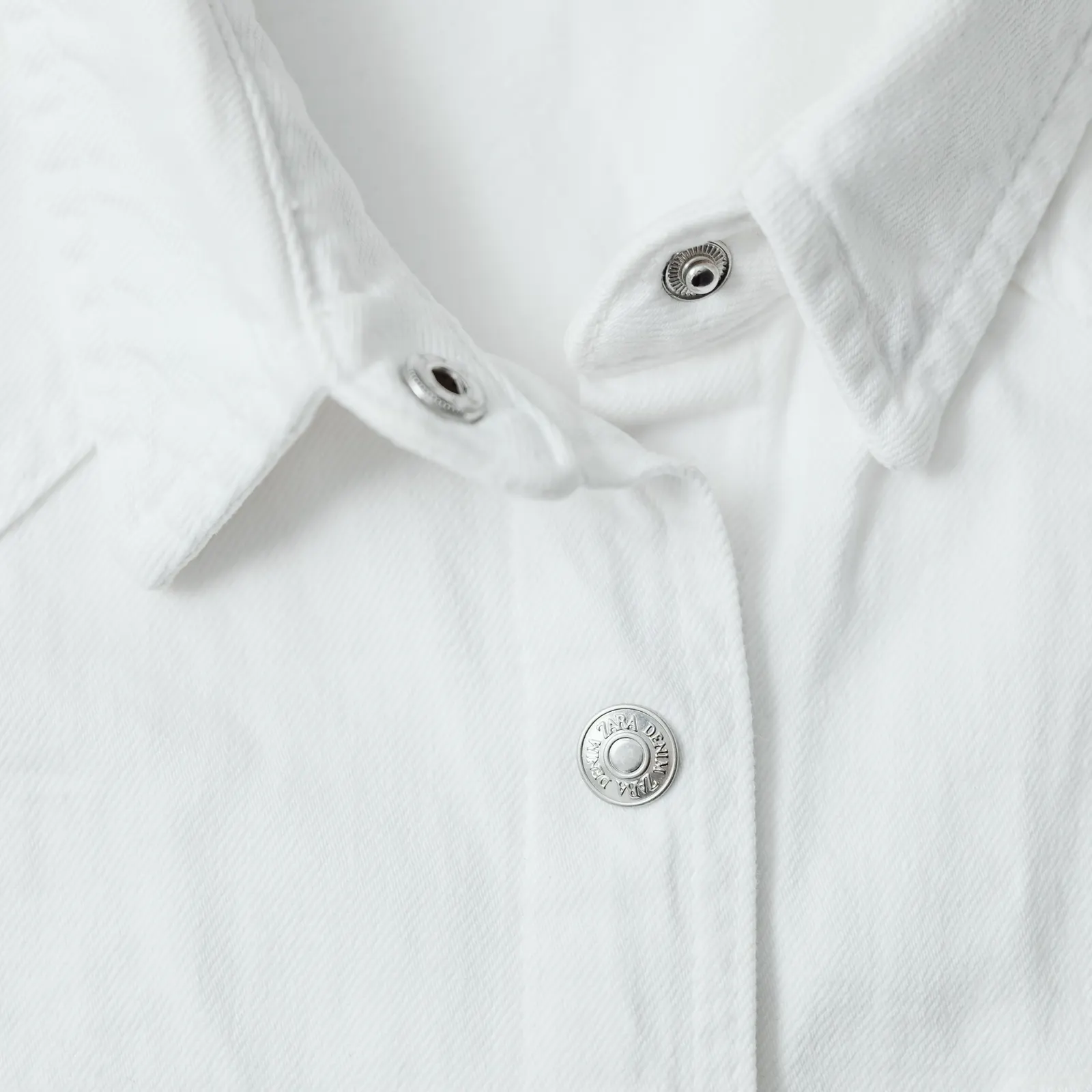 Close view of a white shirt collar and buttons